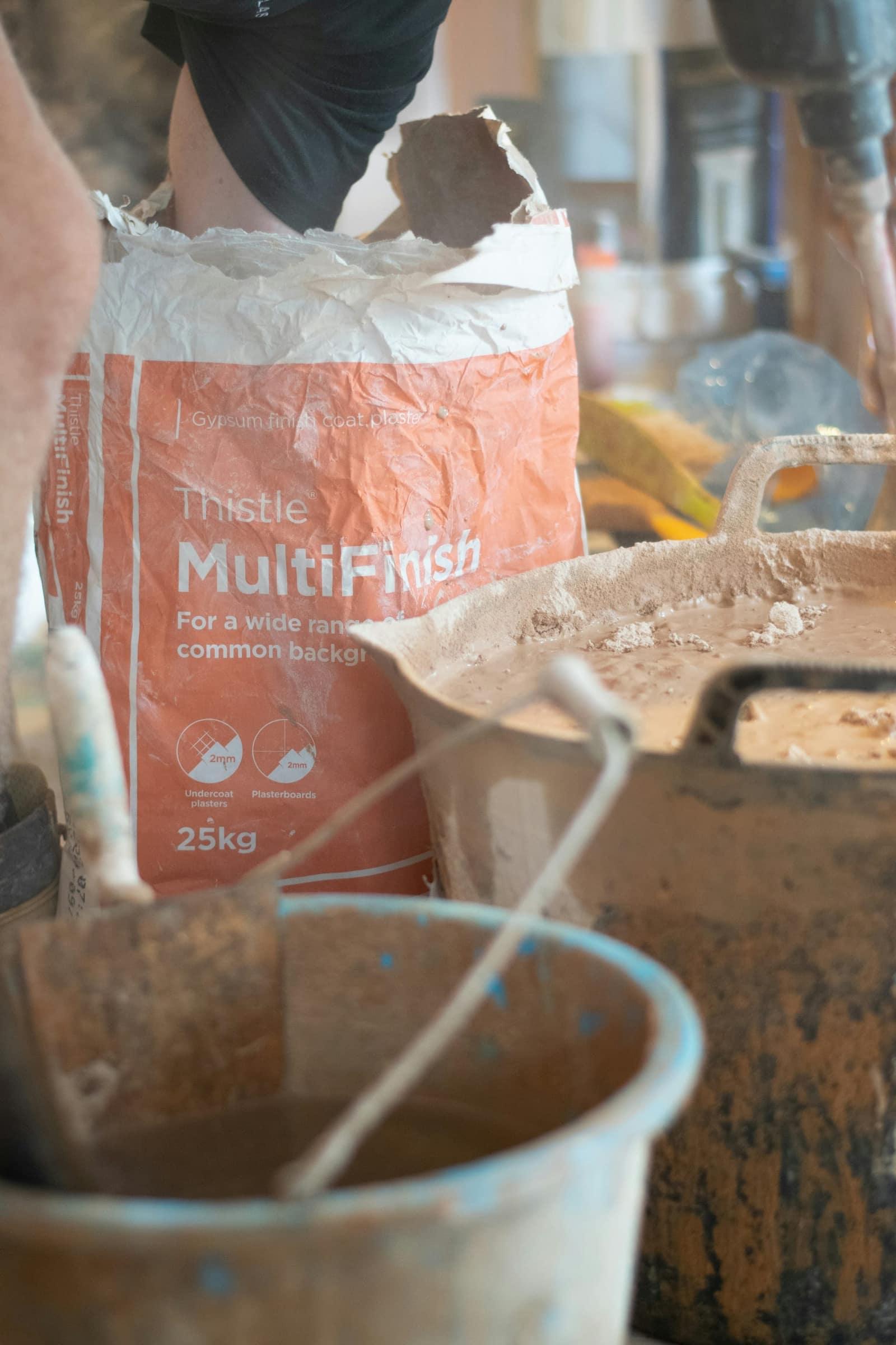 Plasterer mixing base coat on site