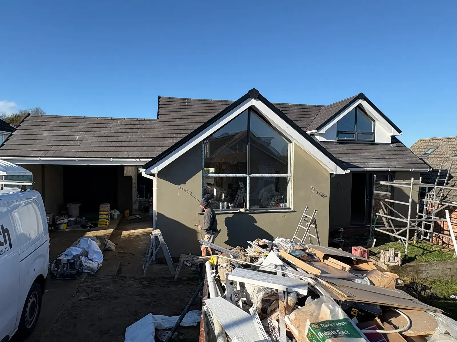 Front elevation of a Dorset bungalow renovation with new render and roof, scaffold in shot
