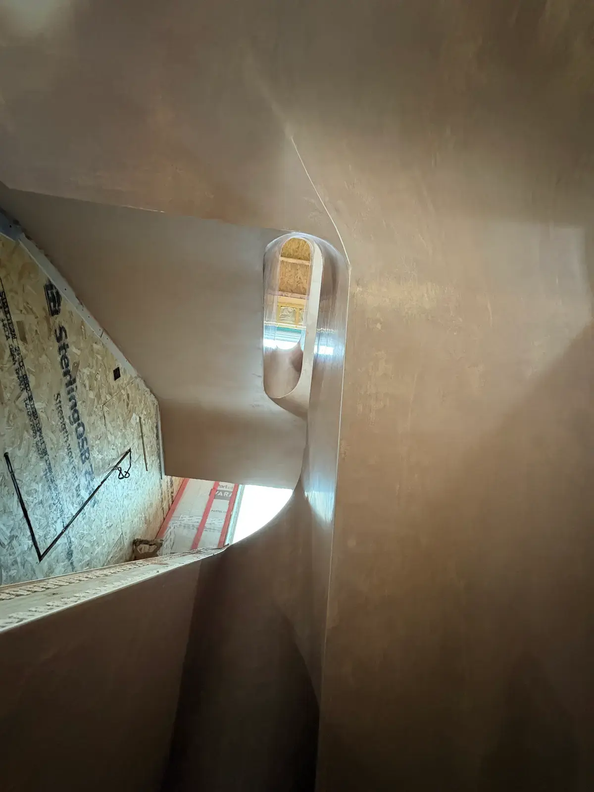 Curved plaster around a skylight opening, freshly skimmed